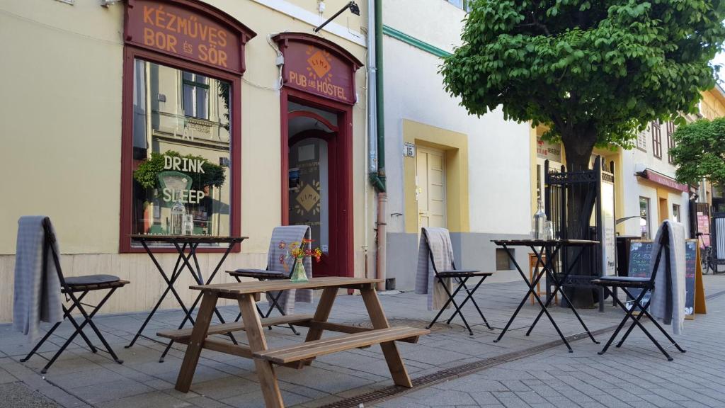 杰尔Lima Hostel Győr的街上的一张木头野餐桌和椅子