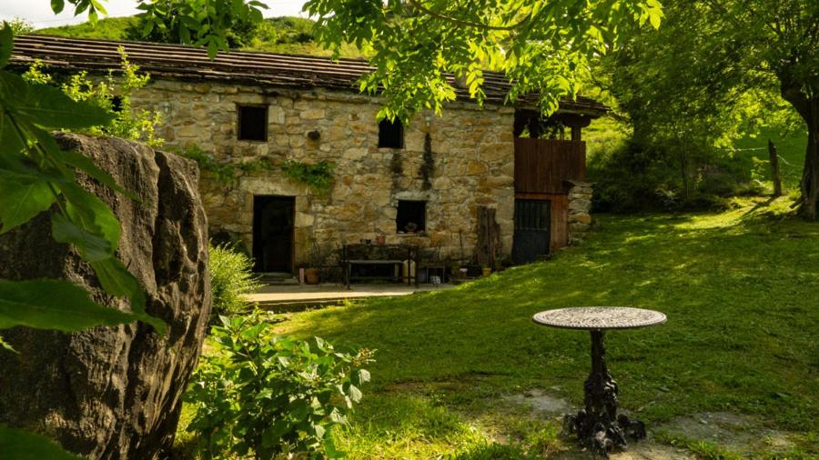 San Roque de RíomieraCabaña en las montañas的石头建筑,前面有桌子