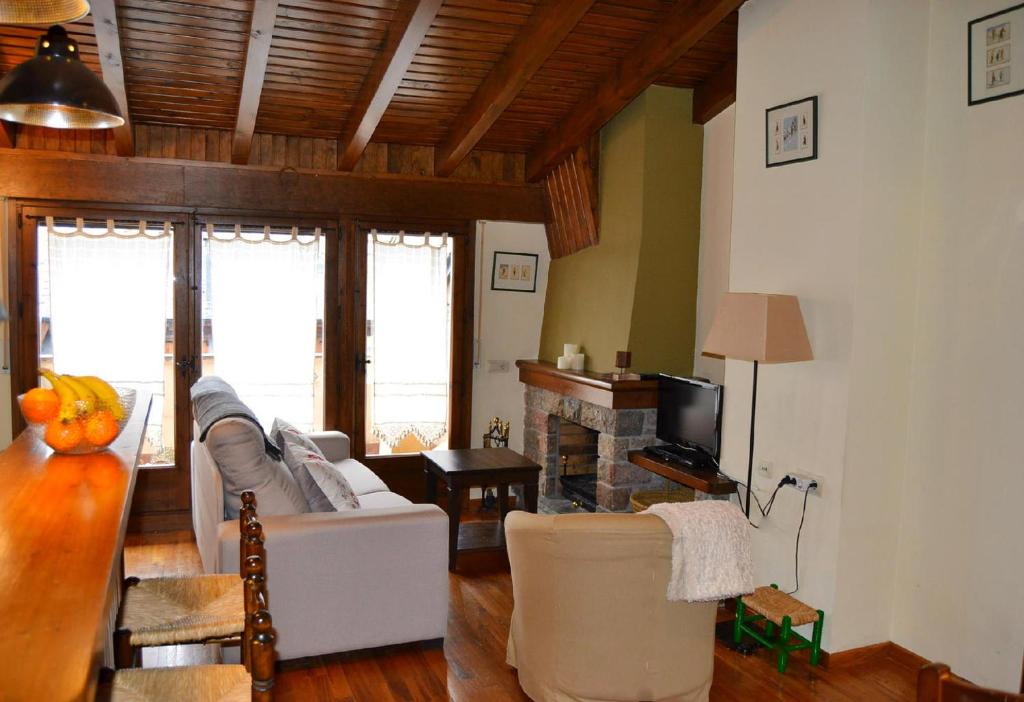 贝尔维尔德赛当亚Bonito ático en Bellver de Cerdanya的客厅配有白色沙发和壁炉
