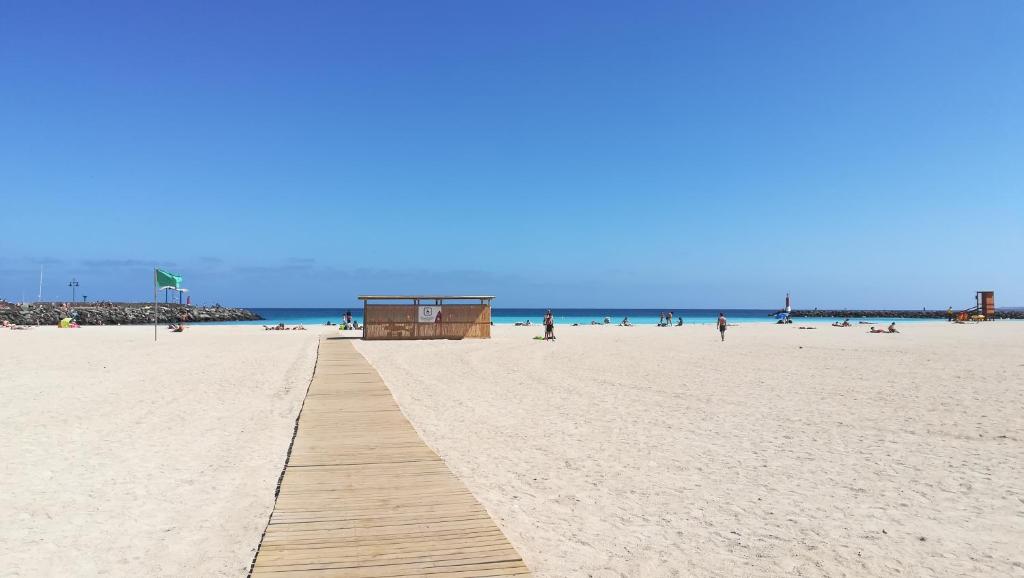 罗萨里奥港Bed & Breakfast Descanso y Relax的沙滩上,沙滩上有木路