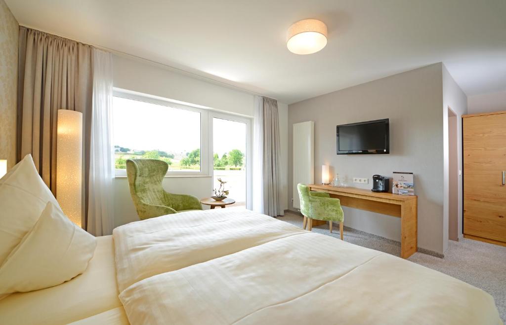 WahlrodHotel Hammermühle的配有一张床和一张书桌的酒店客房