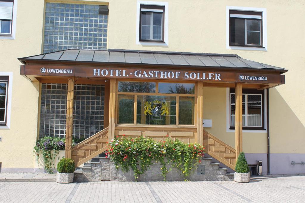 伊斯马宁Hotel und Gasthof Soller的一座建筑前鲜花盛开的酒店出纳员