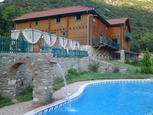 Mousthéni狄俄尼索斯村度假酒店的大楼前带游泳池的房子