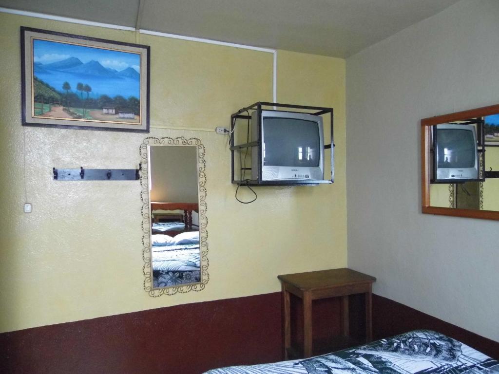 危地马拉Hotel Landivar Zona 7的一间带镜子、电视和床的卧室