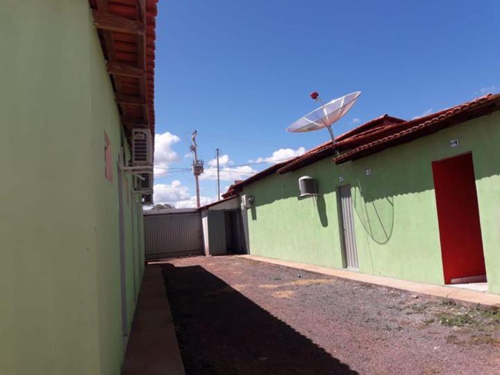 RiachãoPousada Alvorada的绿色建筑,带有栅栏和卫星