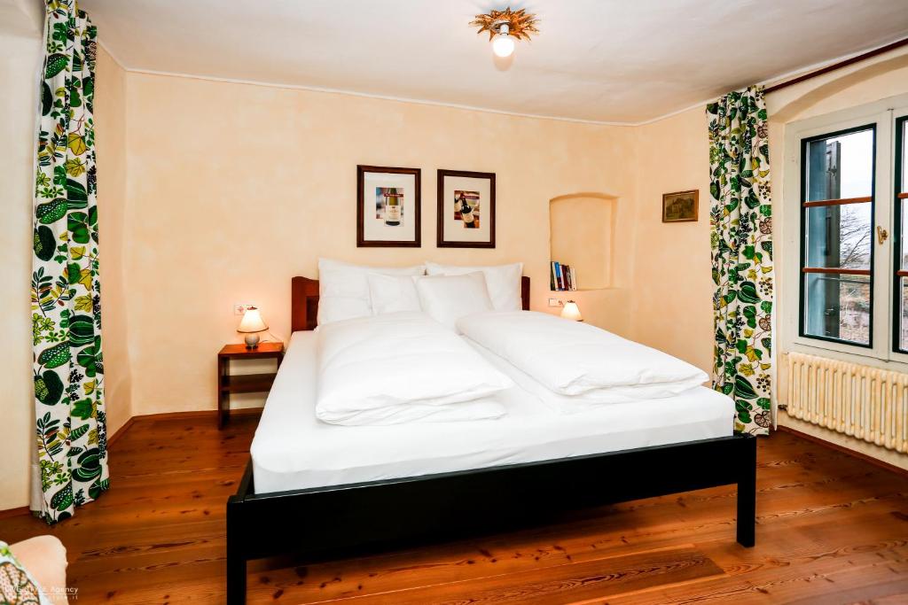 卡尔达罗Weinbergsuite Panholzer的卧室配有白色大床和白色枕头