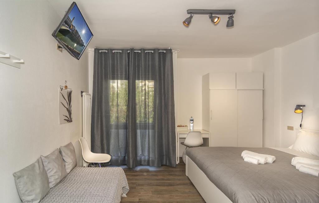 比萨BB L'APPRODO的一间卧室配有一张床、一张沙发和一个窗口