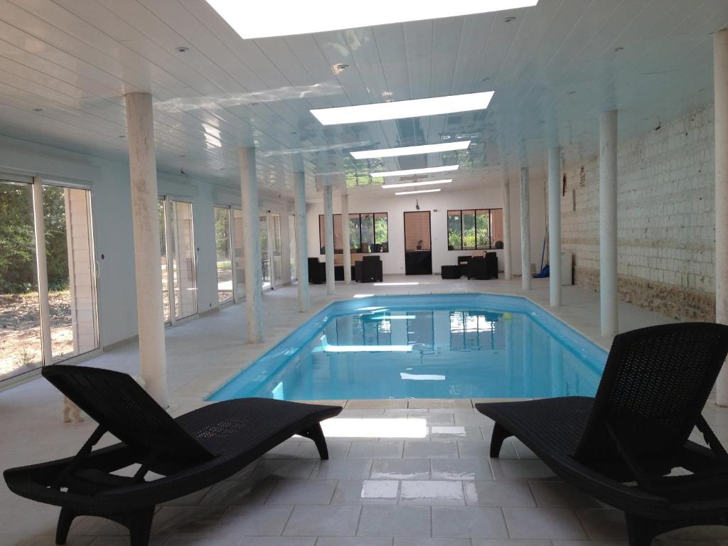 Grèges戈尔热城堡酒店的一个带两把椅子的大型游泳池和一个游泳池