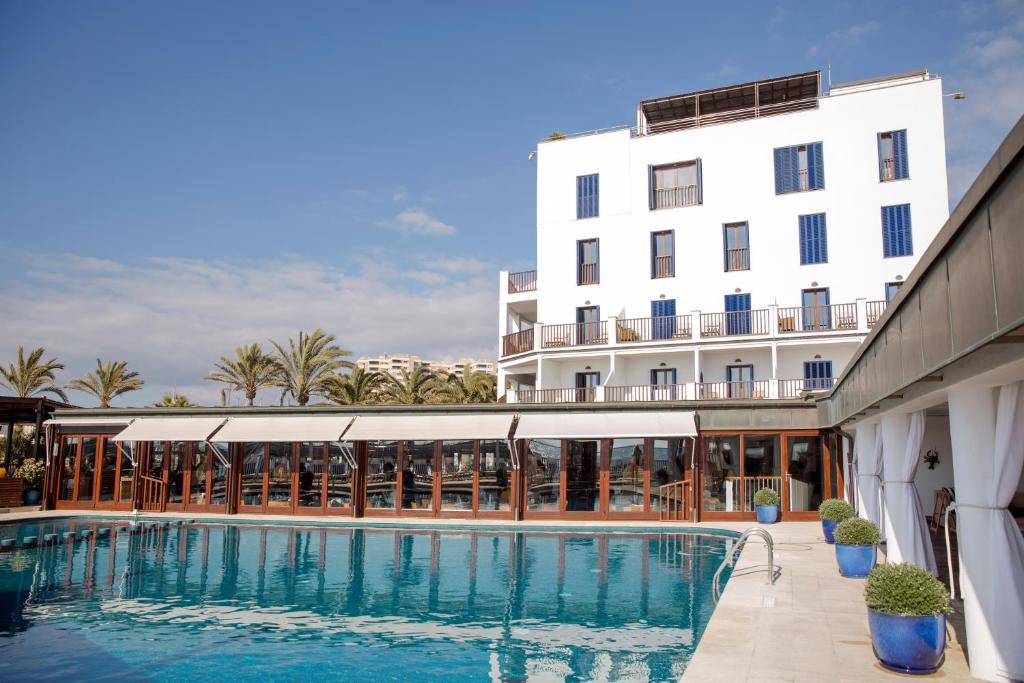 马略卡岛帕尔马博尔题索尔酒店＆餐厅的大楼前设有游泳池的酒店