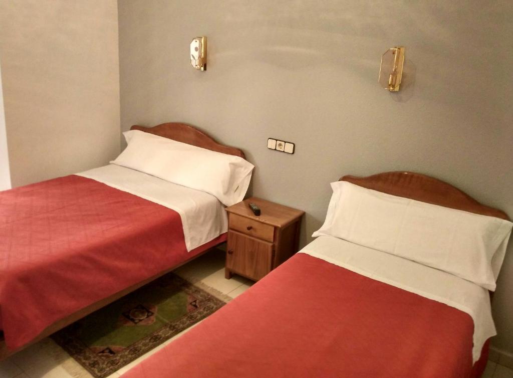 马德里Hostal Gaudí的两张睡床彼此相邻,位于一个房间里