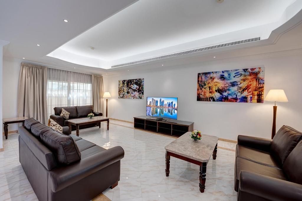 迪拜J5 Four Bedroom Villa Holiday home in Mirdif的客厅配有两张沙发和一张桌子