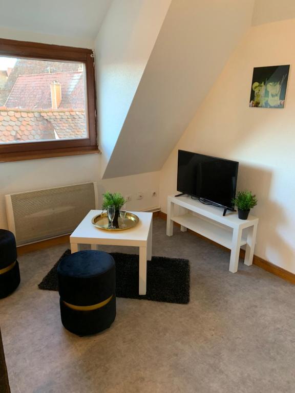 希伯维列Studio à Ribeauvillé的客厅配有电视和桌子