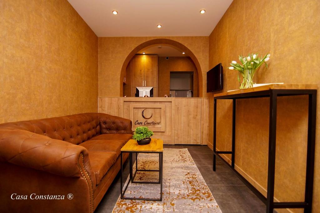腓特烈港Casa Constanza Hotel Garni的客厅配有棕色沙发和桌子