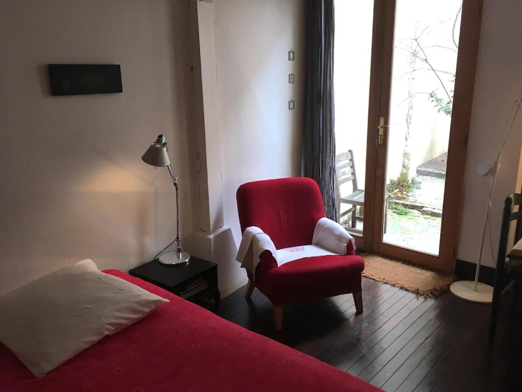 巴黎安妮勒特博加酒店的一间卧室配有红色的床、椅子和窗户