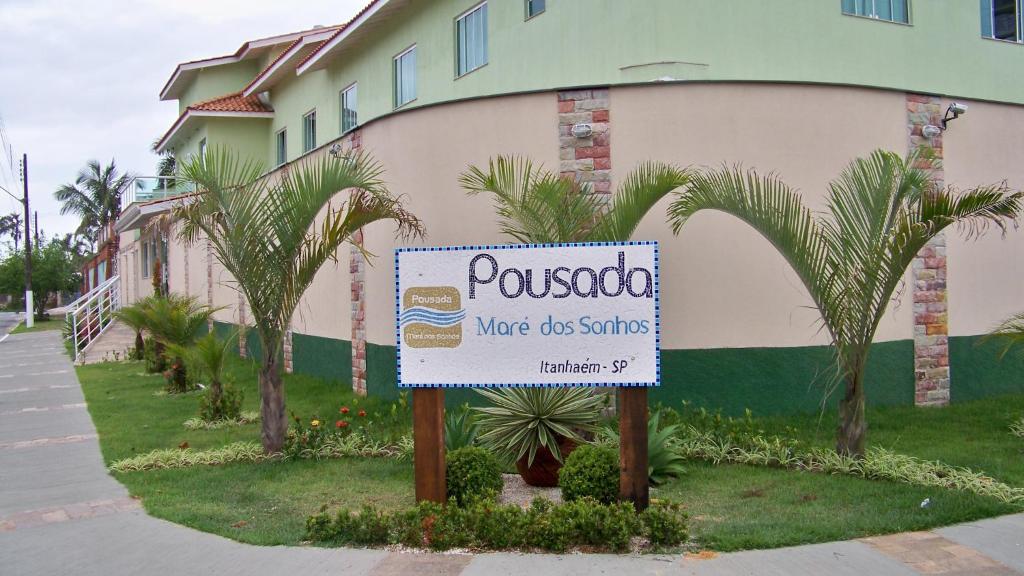 伊塔尼亚恩马雷桑霍斯宾馆的棕榈树建筑前的标志