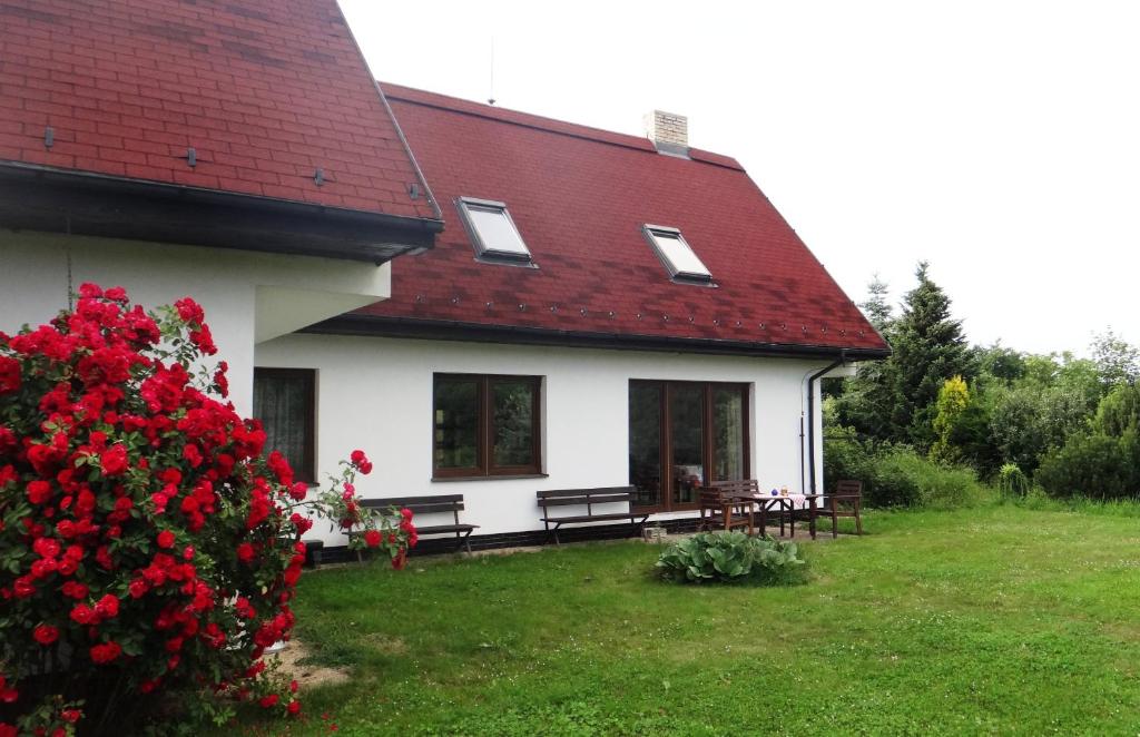 Červená Řečice普拉兹尼诺维顿 - PACL切尔韦纳瑞切度假屋酒店的白色的房子,有红色的屋顶和红色花丛