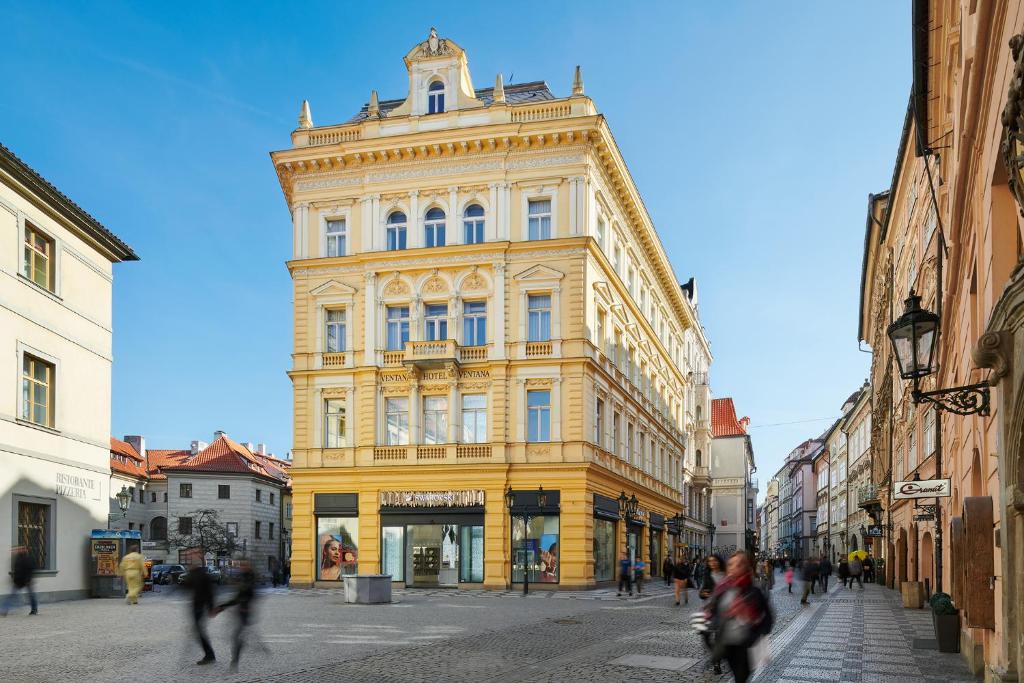 布拉格布拉格维塔纳酒店的一条城市街道上的黄色大建筑