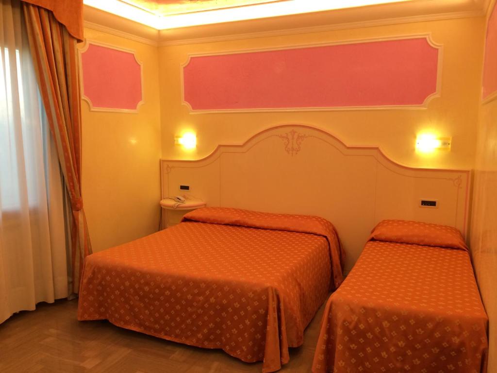 坎帕那鲁皮亚罗坎达扎波图酒店的配有橙色床单的客房内的两张床