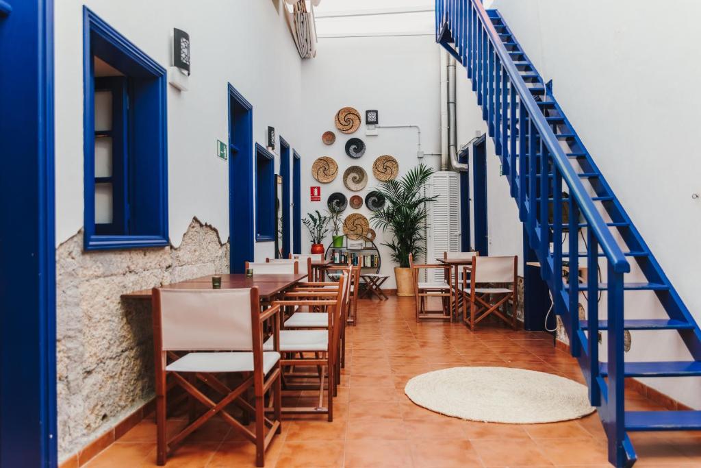 厄尔梅达诺爱思瓦娜旅舍的餐厅设有蓝色的门和木桌及椅子