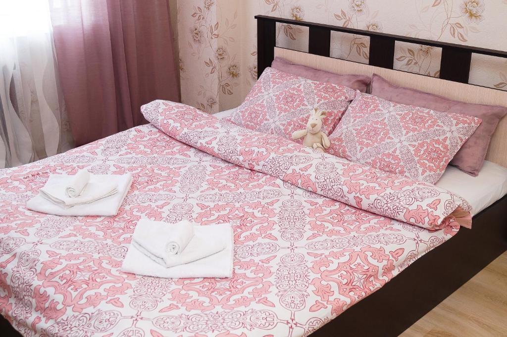 沃洛格达雅罗斯拉夫尔普雷米尼纳科瓦迪金公寓的粉红色和白色的床,上面有两条白色毛巾