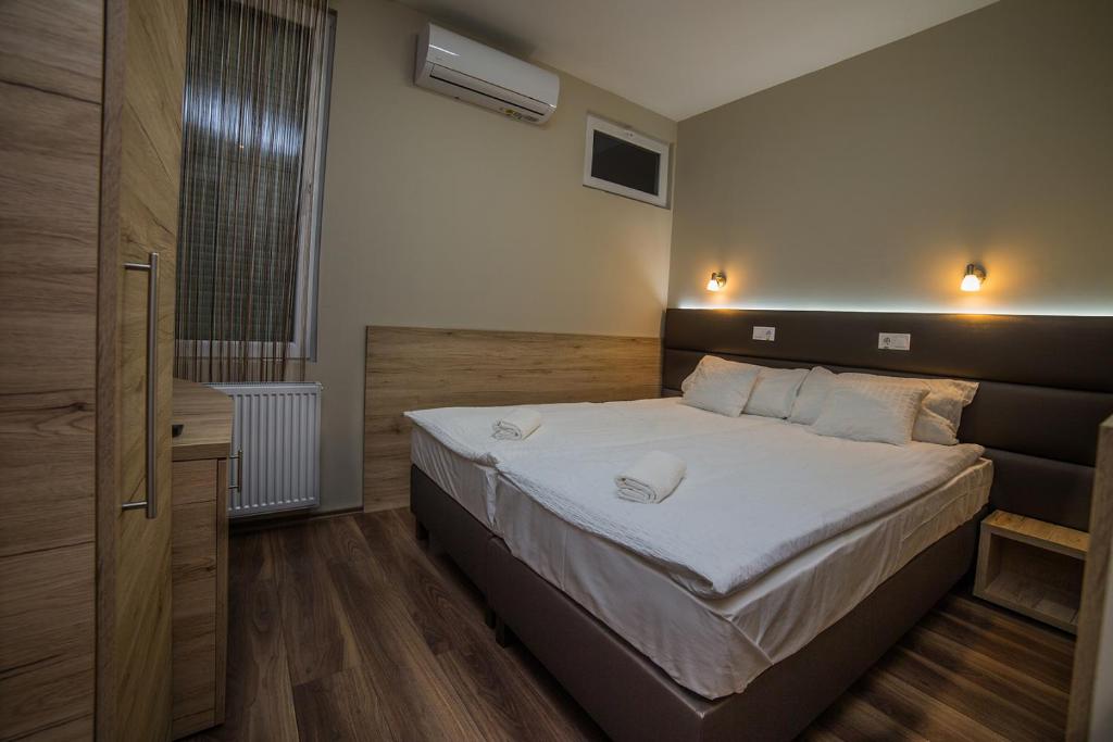 BalassagyarmatSztár Motel Étterem的一间卧室配有一张带白色床单的大床