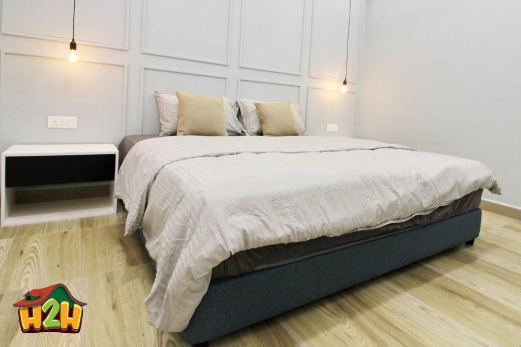 怡保H2H - Sweet Cottage - Octagon的一间卧室设有一张大床和白色的墙壁