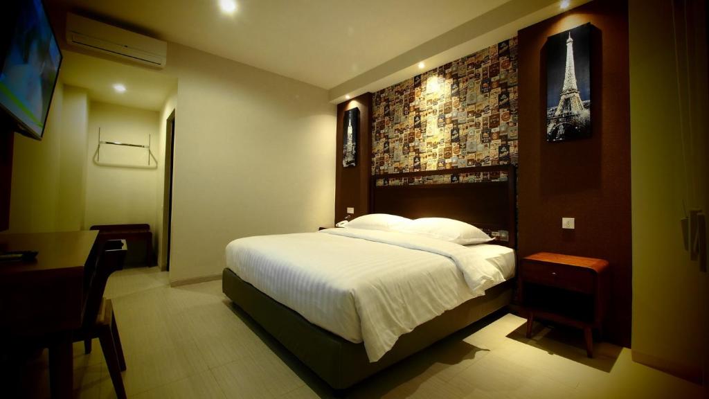 玛琅De Boutique Style Hotel的一间卧室设有一张大床和砖墙