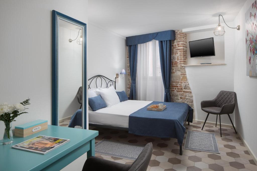 罗维尼Noemi's rooms的酒店客房配有一张床铺、一张桌子和一张书桌。