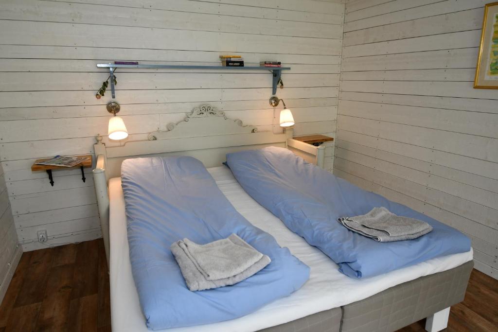 ForsKolarbogård的一张带蓝色床单的床和两张毛巾