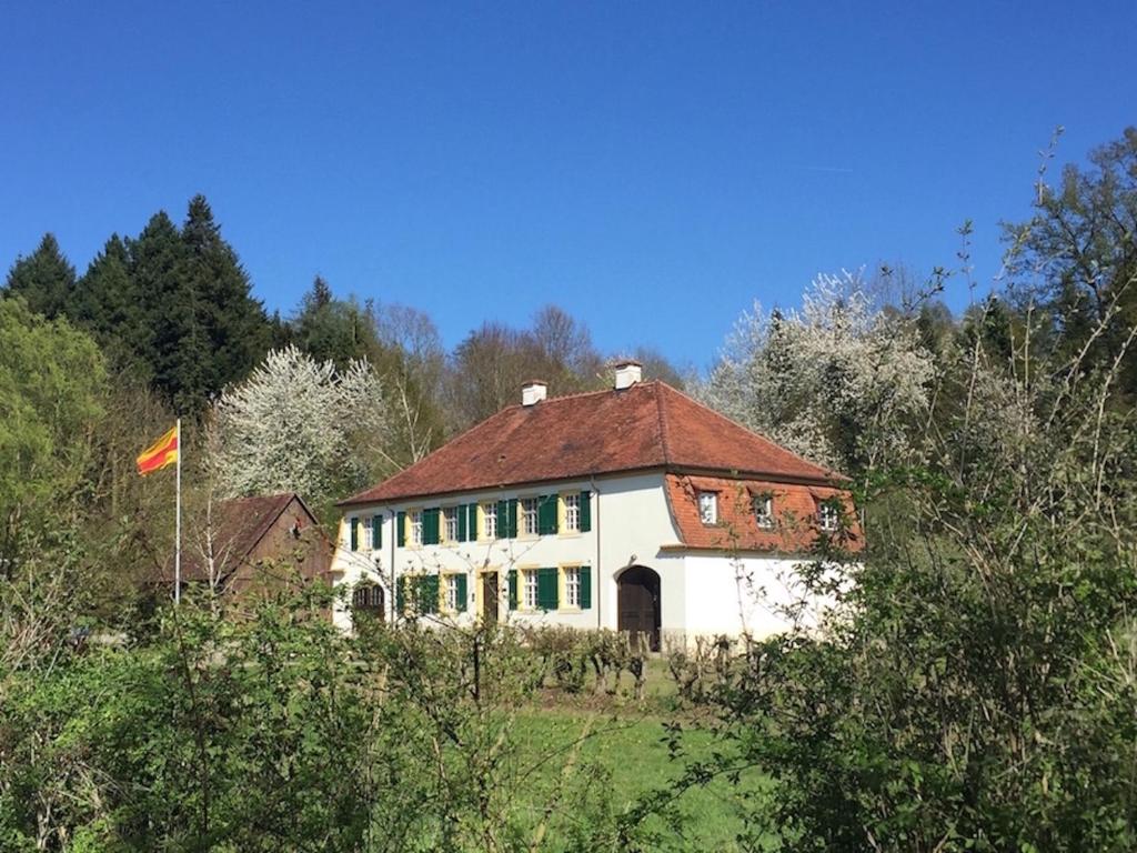 塞勒姆Fischerhaus的一座白色的房子,在田野上有一个红色的屋顶