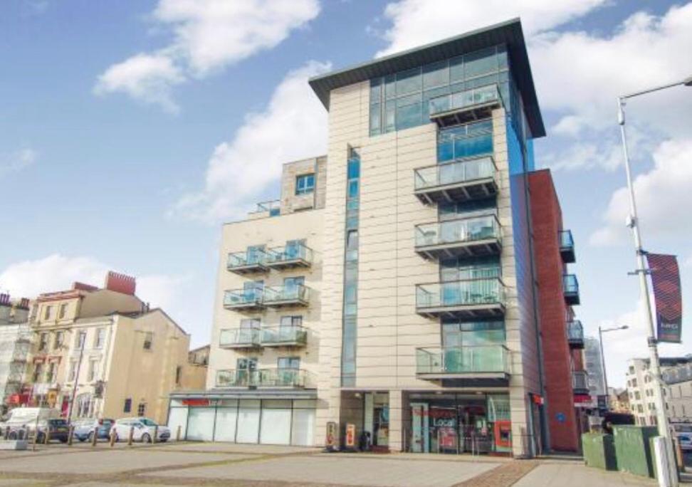 卡迪夫Quayside Apartment in Cardiff Bay的一座高大的建筑,旁边设有阳台