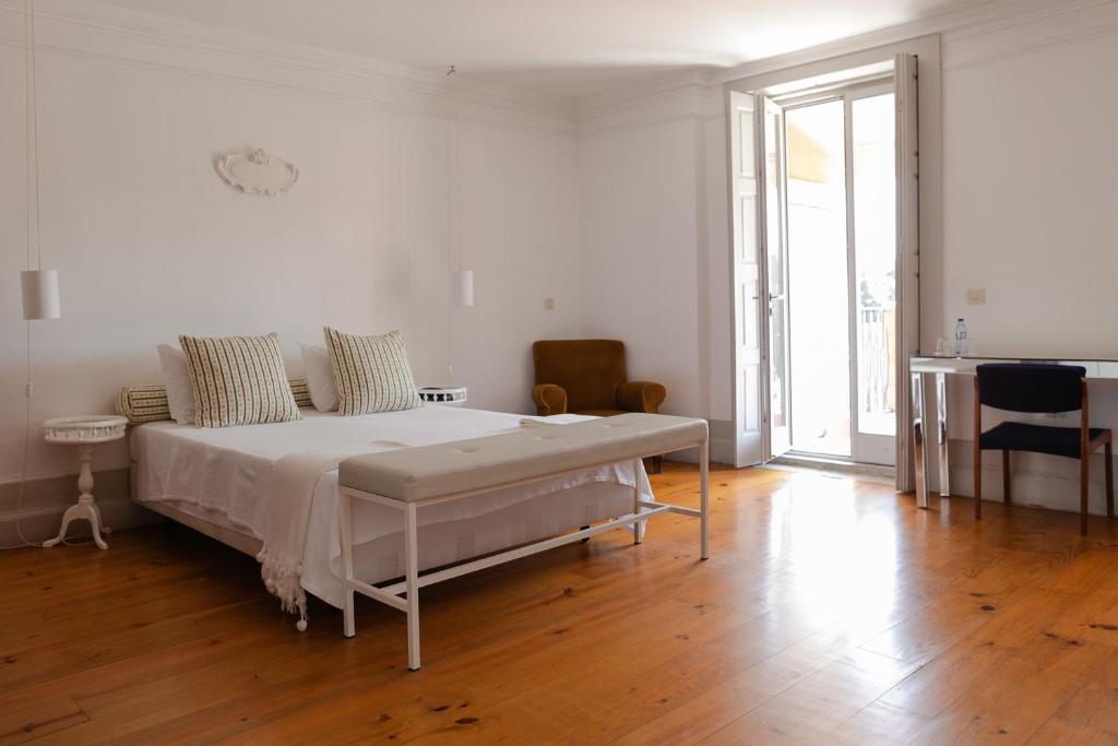 波尔图潘苏鸥非波特酒店的一间铺有木地板的白色卧室,配有一张床