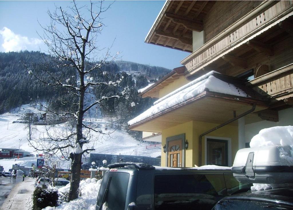 卡顿巴赫加尼克劳科尔酒店的停在雪地的建筑物前面的汽车