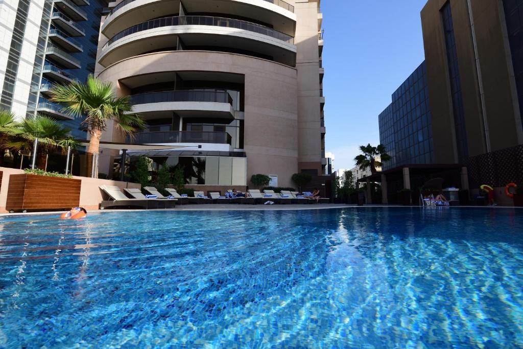 迪拜Majestic City Retreat Hotel的大楼前的大型游泳池