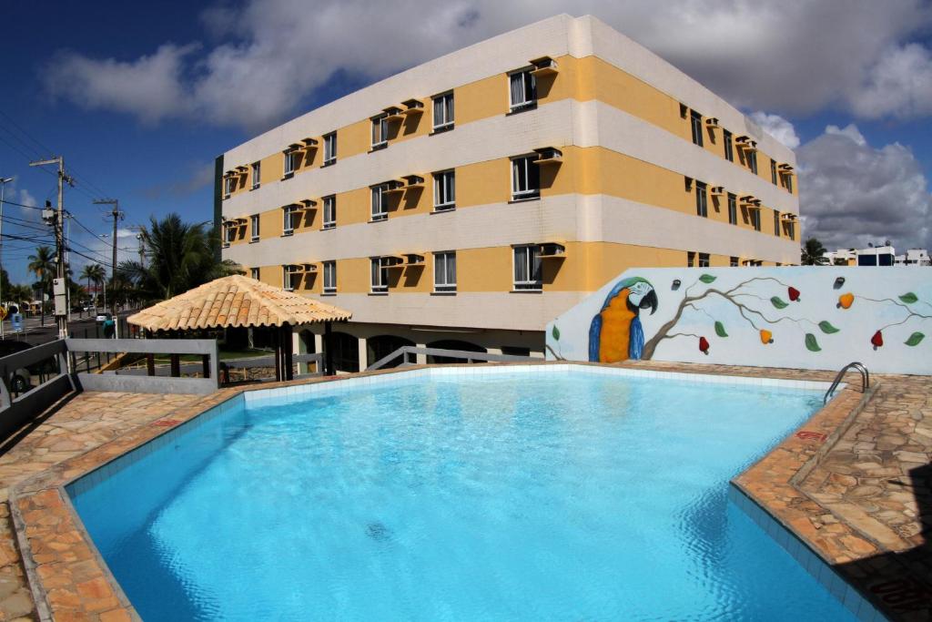 阿拉卡茹纳西门托普拉亚酒店的大楼前设有游泳池的酒店