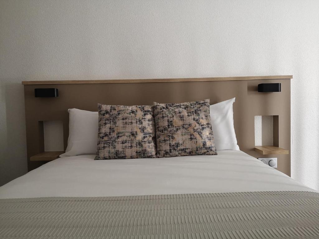 巴黎意大利AM酒店的一张大床,上面有两个枕头
