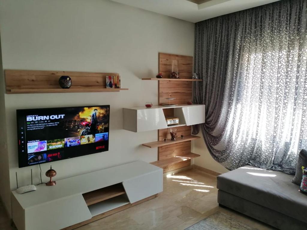 诺阿瑟Luxury résidence Taj Nouaceur的客厅设有壁挂式平面电视。