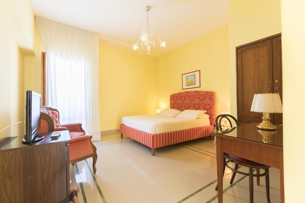 巴里Masseria Sant'Anna的一间卧室配有一张床、一张书桌和一台电视