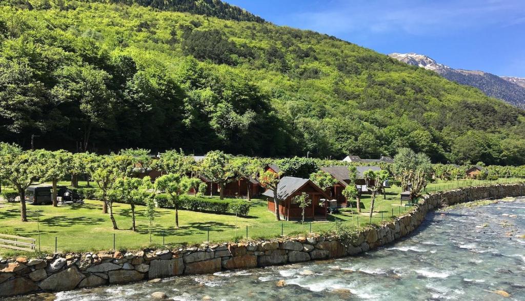 阿洛斯Bungalows Verneda Mountain Resort的河边的石墙度假村