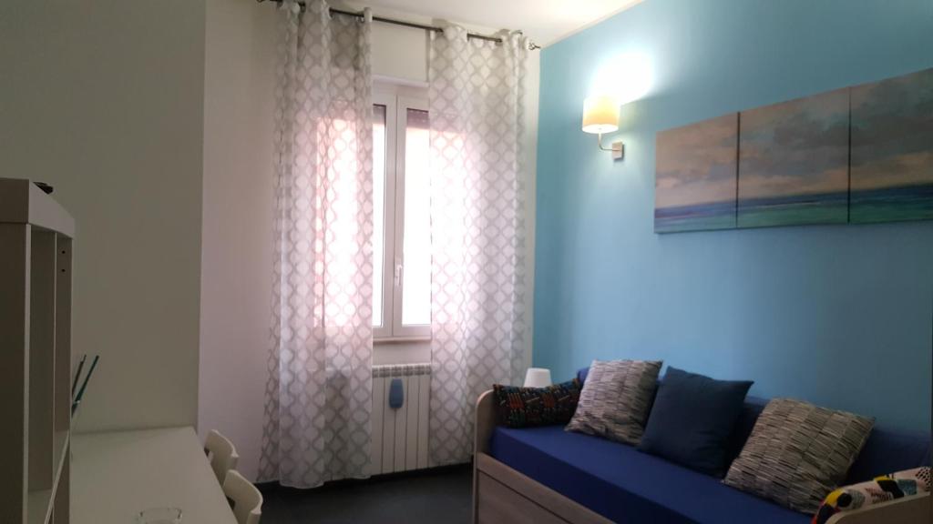 蒙扎DaNicolas Cairoli Apartment的客厅设有蓝色的沙发和窗户。