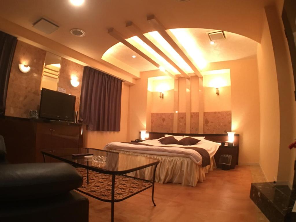 仓敷Hotel Orchid (Adult only)的酒店客房配有一张床铺和一张桌子。
