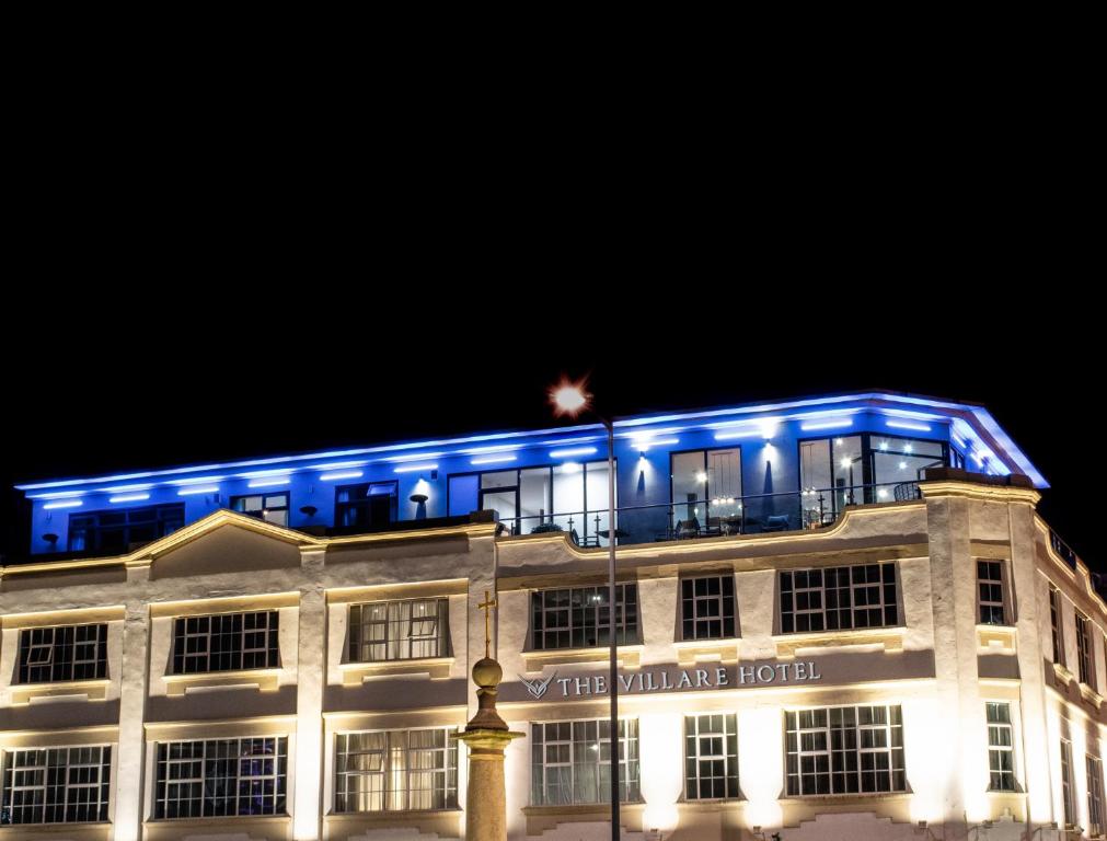 莱斯特Villare Leicester City Centre hotel的一座晚上用蓝色点亮的建筑