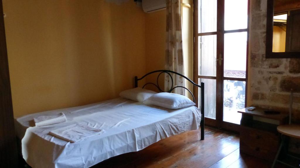 干尼亚凯多尼亚客房酒店的窗户客房内的小床