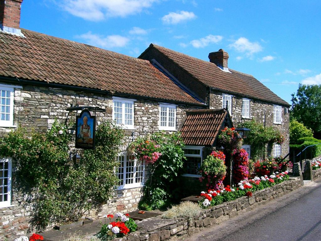PensfordThe Carpenters Arms的一座古老的石头房子,前面有鲜花