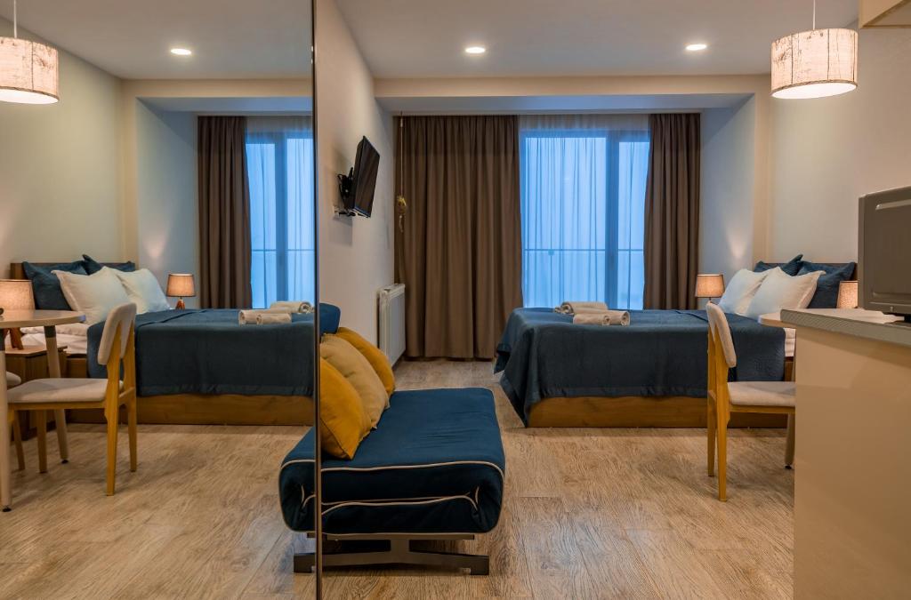古多里Nino's Rooms的酒店客房设有两张床和一张桌子。