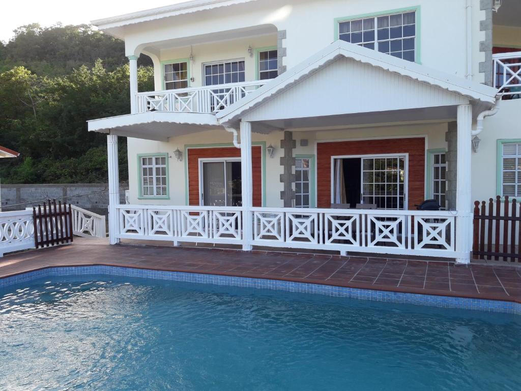 洛尼湾村Bonne View Villa的房屋前有游泳池的房子
