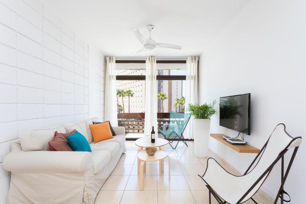 阿罗纳Las Américas Downtown : Prime location accomm.的白色的客厅配有白色的沙发和椅子