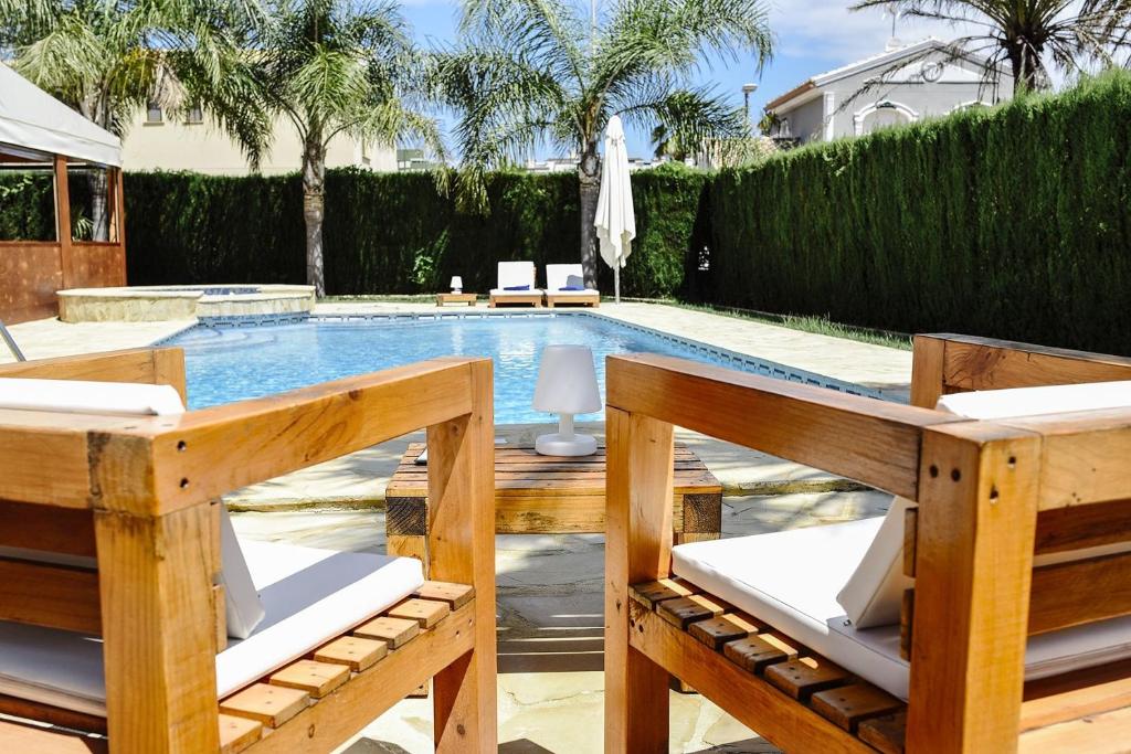 甘迪亚Hotel La Gastrocasa - Adults Only的一个带两把椅子和一张桌子的游泳池