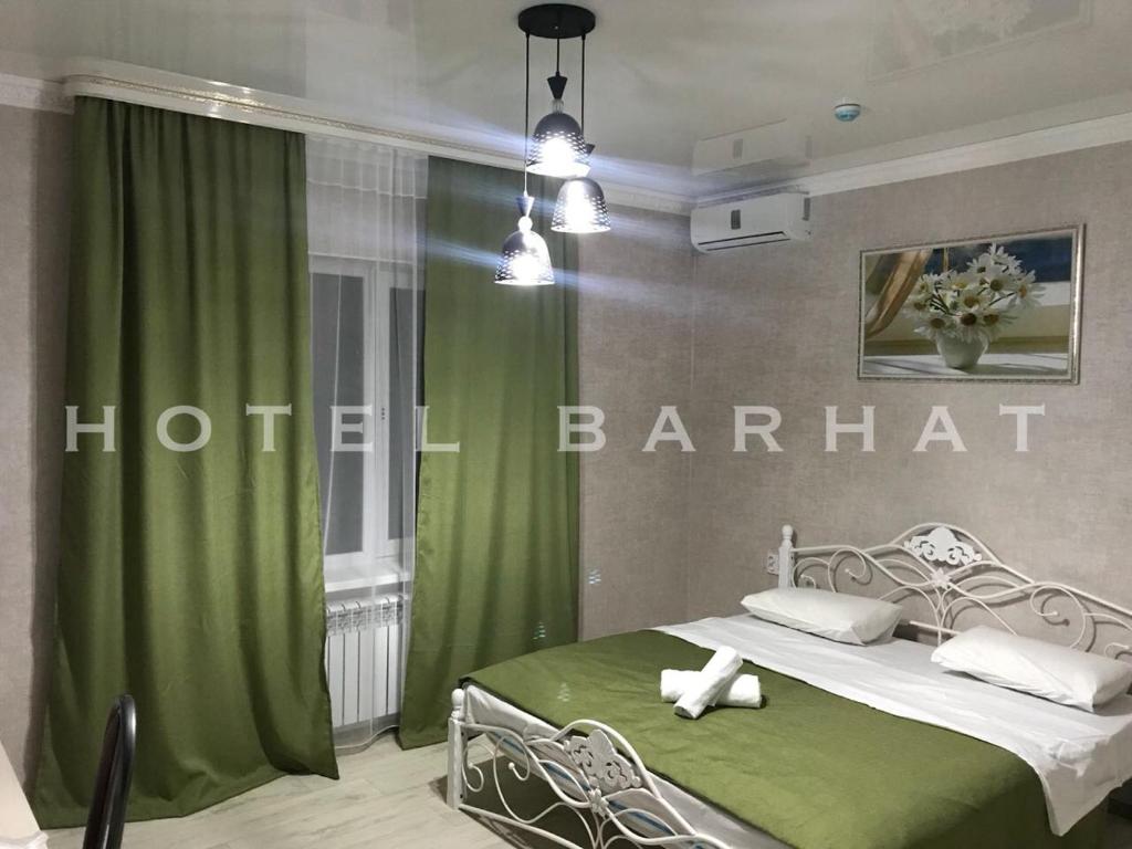 阿克托比Hotel Barhat Аktobe的一间卧室配有床和绿帘