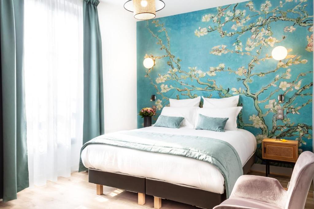 瓦兹河畔欧韦Hotel des Iris的一间卧室设有一张蓝色墙壁的大床
